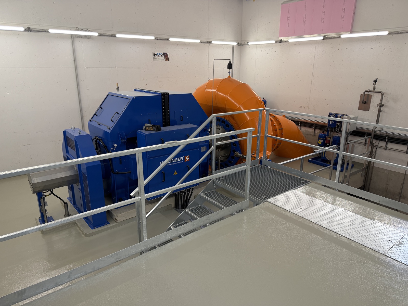 Maschinenraum eines Kleinwasserkraftwerks mit Turbine und Generator